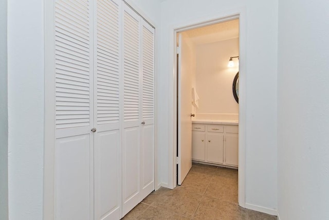corridor featuring light tile patterned floors and baseboards