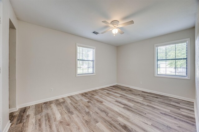 1509 Mitchell Dr, Bonham, TX 75418 - empty room featuring ceiling fan, light wood-style floors, a healthy amount of sunlight, and visible vents