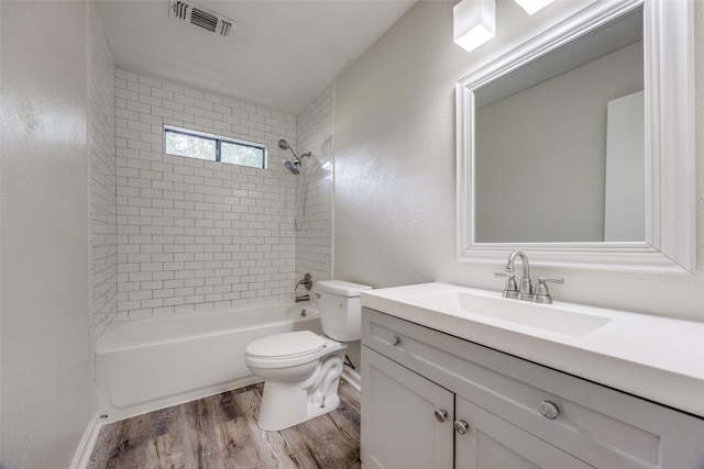 1509 Mitchell Dr, Bonham, TX 75418 - bathroom featuring toilet, visible vents, vanity, wood finished floors, and shower / bathing tub combination