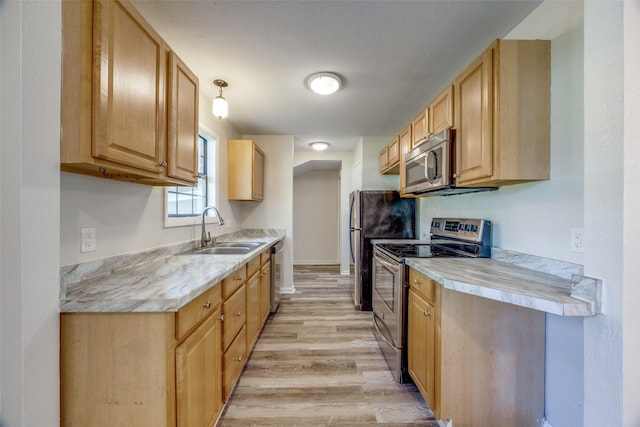 1509 Mitchell Dr, Bonham, TX 75418 - kitchen featuring light wood-style flooring, a sink, stainless steel appliances, baseboards, and light countertops