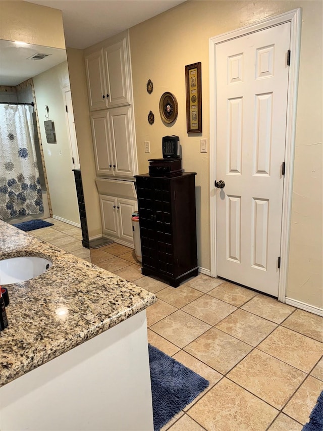 full bathroom featuring baseboards, tile patterned flooring, and vanity