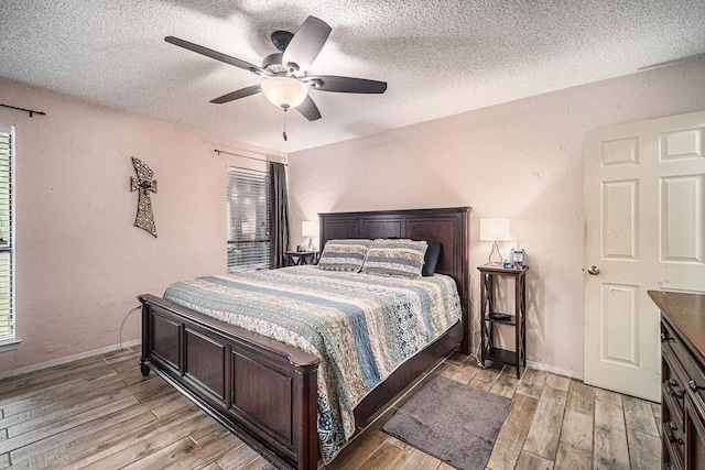 3811 Pelham Mnr, Arlington, TX 76016 - bedroom with baseboards, light wood-style floors, a ceiling fan, and a textured ceiling