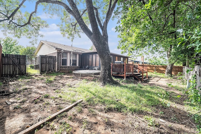 3811 Pelham Mnr, Arlington, TX 76016 - view of yard with a gate, a wooden deck, a trampoline, and a fenced backyard