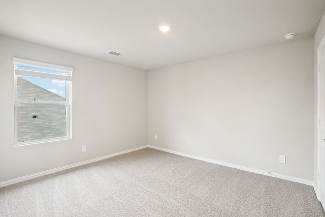 spare room with baseboards, recessed lighting, carpet flooring, and visible vents
