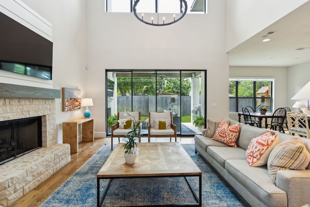 431 Blanning Dr, Dallas, TX 75218 - living room with wood finished floors, visible vents, a fireplace, a chandelier, and a high ceiling