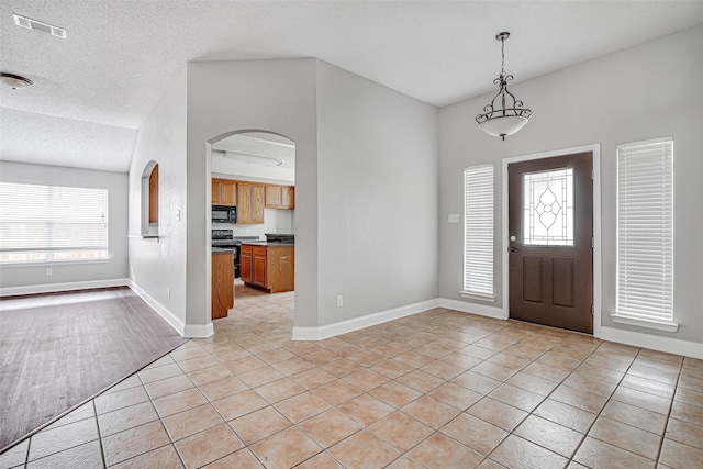 1001 Benjamin Dr, Burleson, TX 76028 - entryway with a textured ceiling, visible vents, baseboards, arched walkways, and light tile patterned flooring