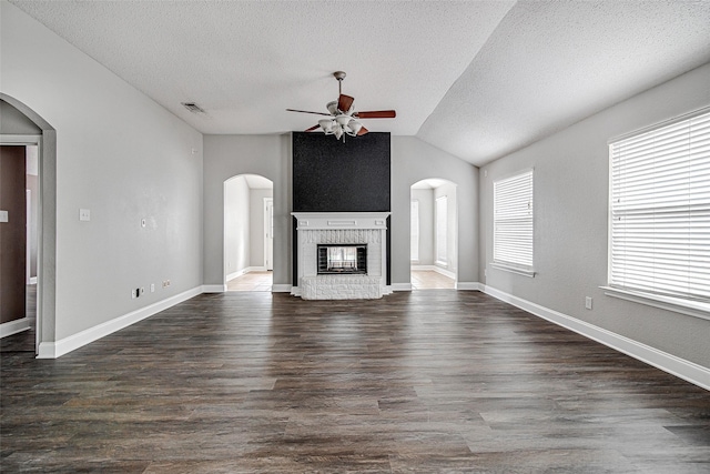 1001 Benjamin Dr, Burleson, TX 76028 - unfurnished living room with a ceiling fan, lofted ceiling, a textured ceiling, visible vents, and a brick fireplace