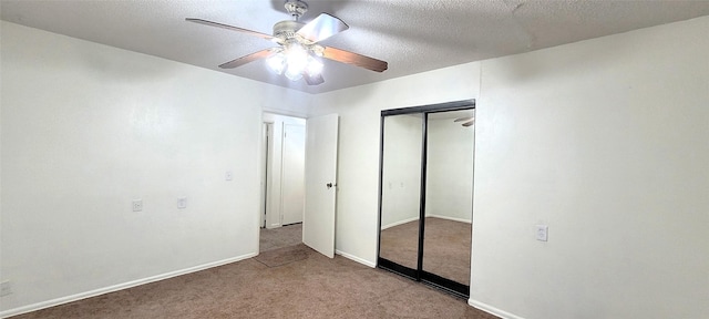unfurnished bedroom with a closet, a textured ceiling, carpet, a ceiling fan, and baseboards