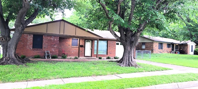 single story home with a front lawn and brick siding