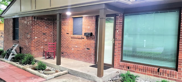 view of exterior entry featuring brick siding