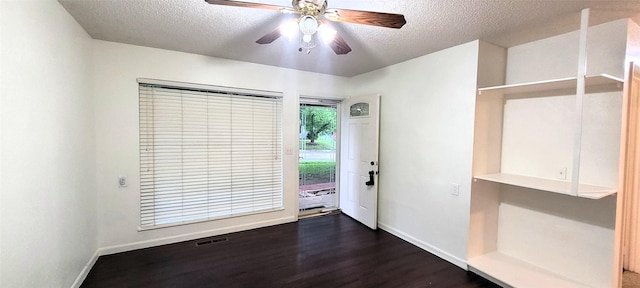 entryway featuring a textured ceiling, visible vents, baseboards, and dark wood-type flooring