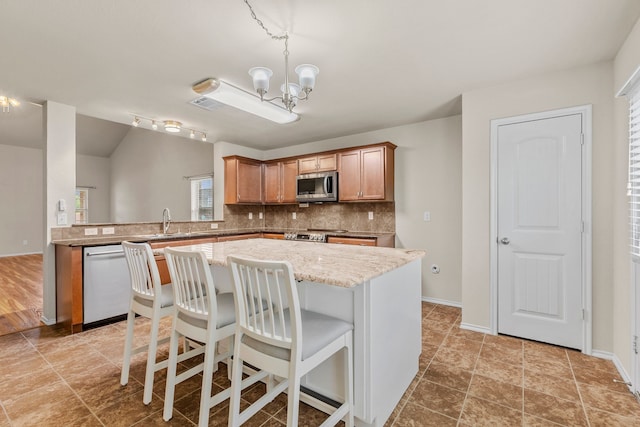 kitchen with tasteful backsplash, visible vents, an inviting chandelier, a center island, and appliances with stainless steel finishes