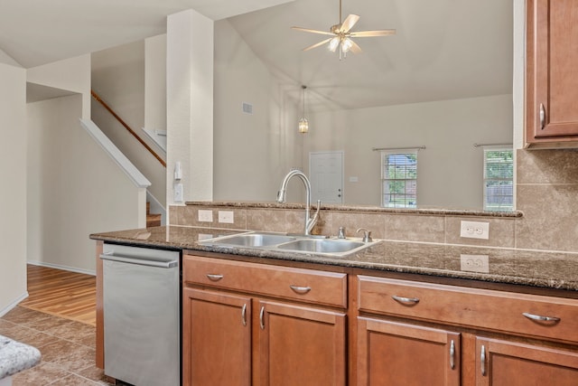 kitchen with dishwasher, brown cabinetry, tasteful backsplash, and a sink