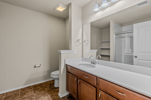 full bathroom featuring toilet, vanity, visible vents, a stall shower, and baseboards