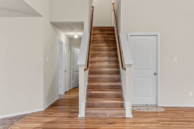 stairs with baseboards and wood finished floors