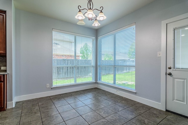 unfurnished dining area with tile patterned flooring, a chandelier, baseboards, and a healthy amount of sunlight