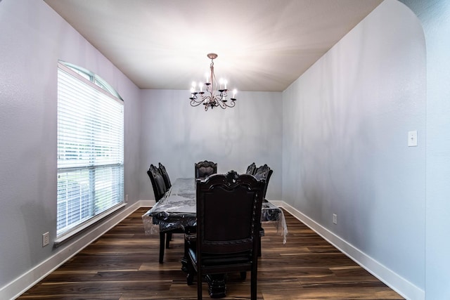 dining room with baseboards, a notable chandelier, and dark wood-type flooring