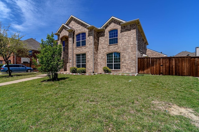 traditional-style home featuring brick siding, fence, and a front yard