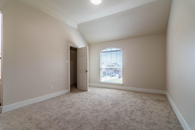 unfurnished bedroom with vaulted ceiling, carpet flooring, and baseboards