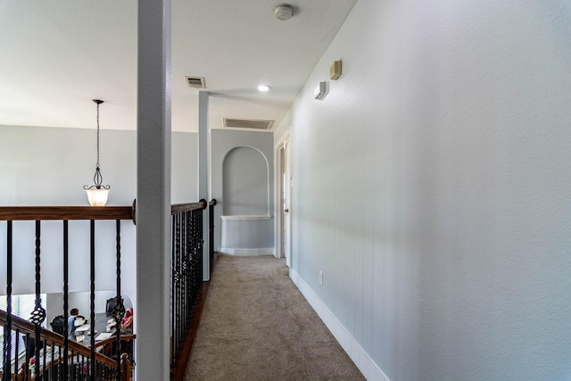 hall with carpet, baseboards, and visible vents
