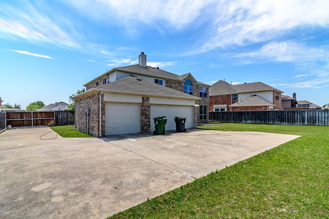 rear view of house with a yard, brick siding, fence, a garage, and concrete driveway