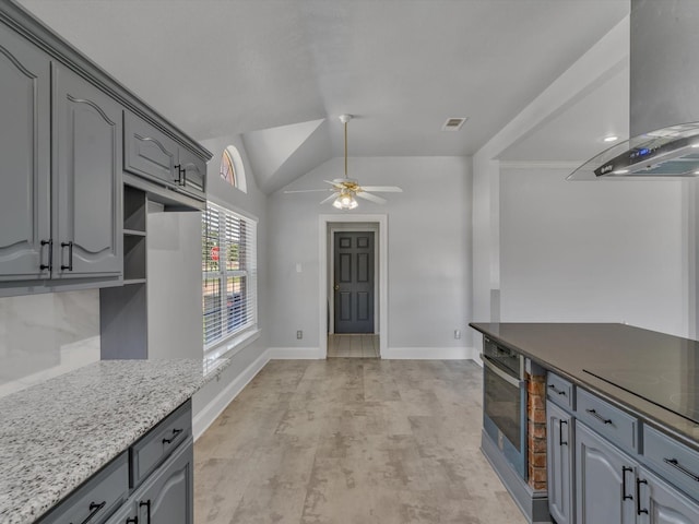 kitchen with island exhaust hood, gray cabinets, a ceiling fan, stainless steel oven, and lofted ceiling