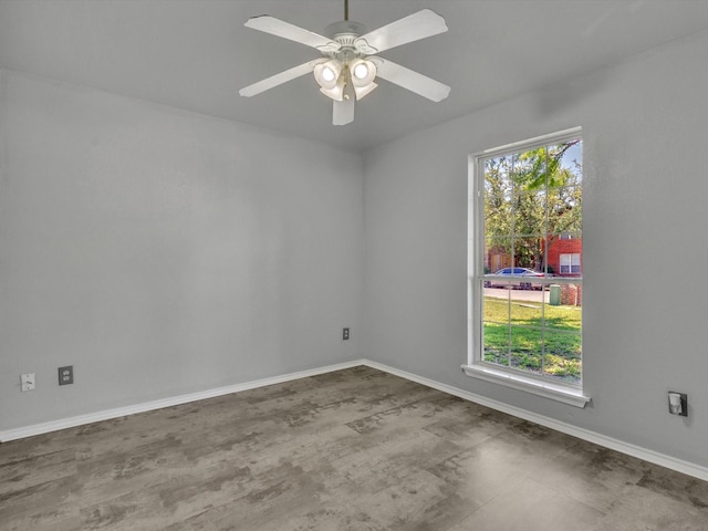 empty room with a ceiling fan and baseboards