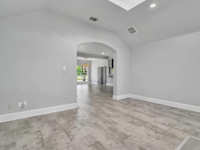 empty room featuring lofted ceiling, arched walkways, baseboards, and recessed lighting