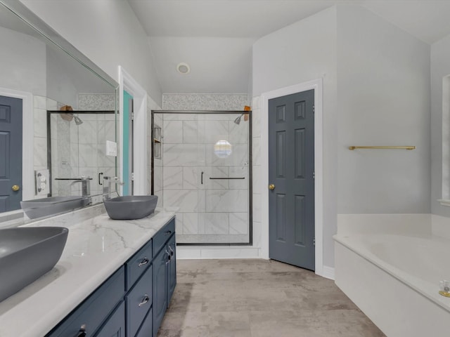 bathroom featuring a stall shower, double vanity, a garden tub, and baseboards