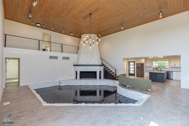718 Byrd Dr, Abilene, TX 79601 - living area with track lighting, wooden ceiling, a chandelier, a towering ceiling, and a fireplace