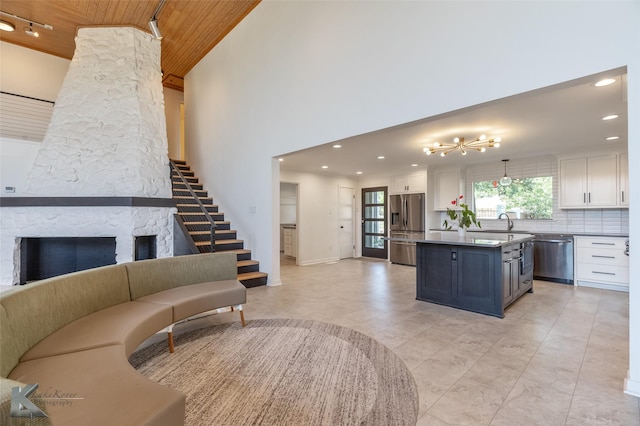 718 Byrd Dr, Abilene, TX 79601 - kitchen featuring stainless steel appliances, white cabinets, open floor plan, a kitchen island, and wood ceiling
