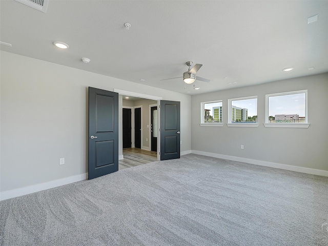 unfurnished room with visible vents, recessed lighting, light carpet, a ceiling fan, and baseboards