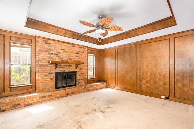 107 Russell Dr, Highland Village, TX 75077 - unfurnished living room featuring carpet floors, a ceiling fan, a fireplace, a raised ceiling, and crown molding
