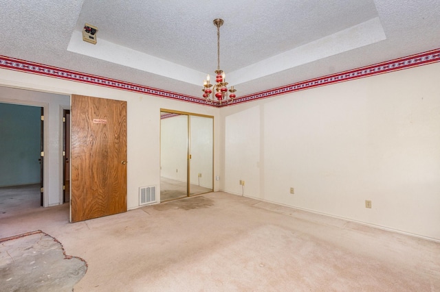 107 Russell Dr, Highland Village, TX 75077 - carpeted spare room featuring a tray ceiling, a textured ceiling, and a chandelier