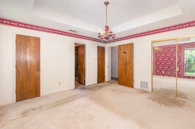 107 Russell Dr, Highland Village, TX 75077 - unfurnished bedroom with a raised ceiling, a chandelier, carpet, and multiple closets