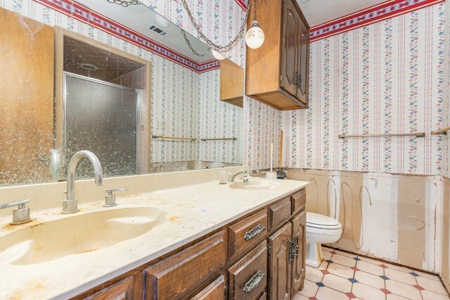 107 Russell Dr, Highland Village, TX 75077 - bathroom featuring wallpapered walls, a stall shower, a wainscoted wall, toilet, and double vanity