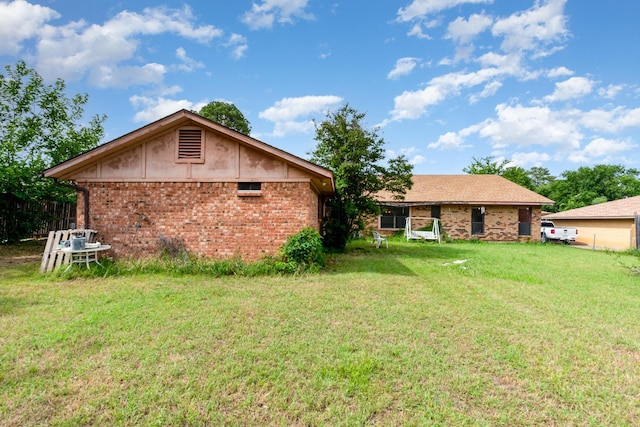 107 Russell Dr, Highland Village, TX 75077 - rear view of property with a lawn and brick siding