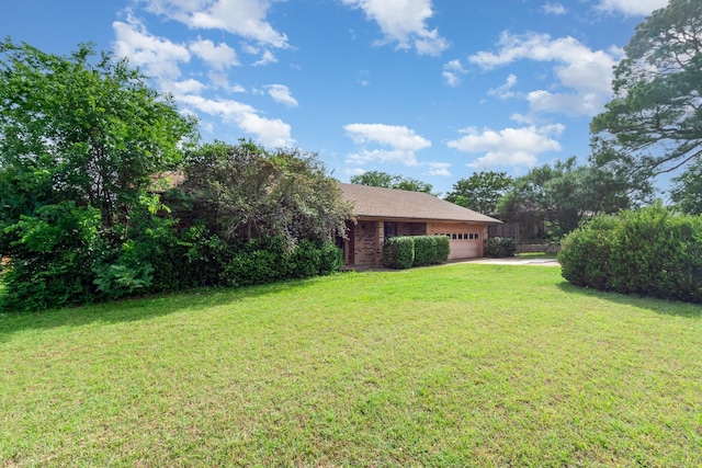 107 Russell Dr, Highland Village, TX 75077 - view of grassy yard featuring an attached garage and concrete driveway