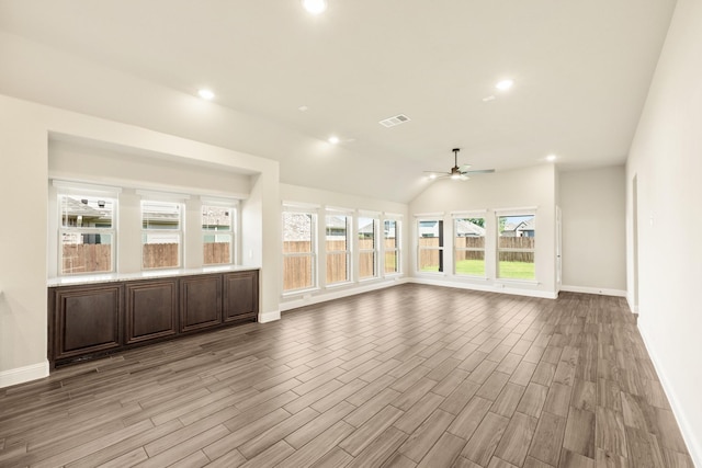 unfurnished living room with baseboards, ceiling fan, light wood finished floors, recessed lighting, and vaulted ceiling