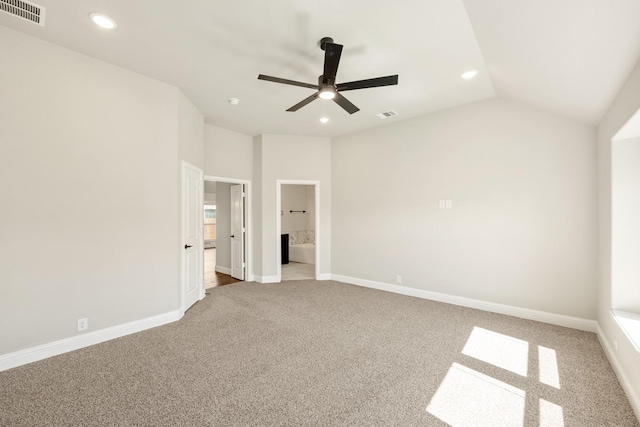 unfurnished bedroom featuring recessed lighting, light colored carpet, lofted ceiling, ensuite bath, and baseboards