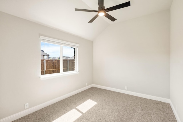 spare room with carpet, baseboards, ceiling fan, and lofted ceiling