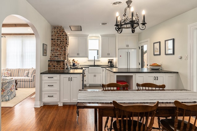 5107 Milam St, Dallas, TX 75206 - kitchen featuring dark countertops, dark wood finished floors, built in refrigerator, visible vents, and white cabinetry