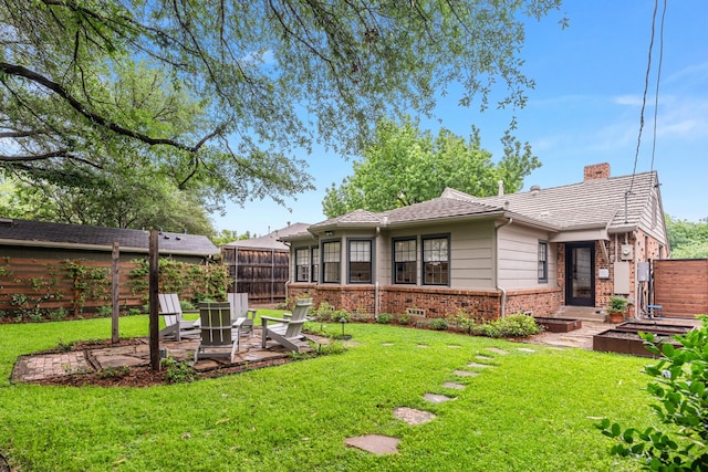 5107 Milam St, Dallas, TX 75206 - back of property with a patio, a chimney, fence, a lawn, and brick siding
