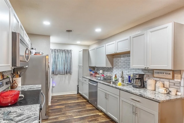 1773 Westview Dr, Abilene, TX 79603 - kitchen featuring appliances with stainless steel finishes, dark wood-style flooring, decorative backsplash, light stone counters, and recessed lighting