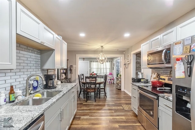 1773 Westview Dr, Abilene, TX 79603 - kitchen featuring stainless steel appliances, a sink, a chandelier, decorative backsplash, and recessed lighting