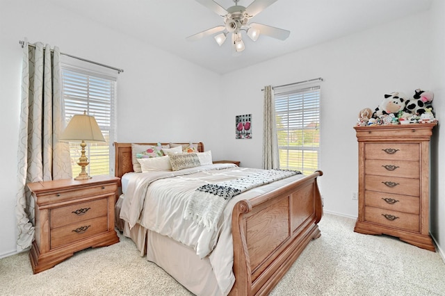 bedroom with multiple windows, light carpet, baseboards, and ceiling fan