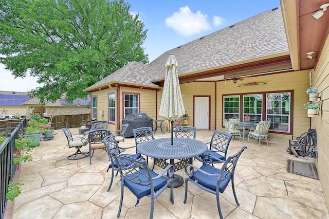 view of patio with area for grilling, outdoor dining area, ceiling fan, and a fenced backyard