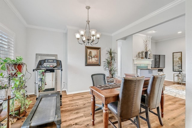 dining space featuring baseboards, light wood-style floors, a chandelier, and crown molding