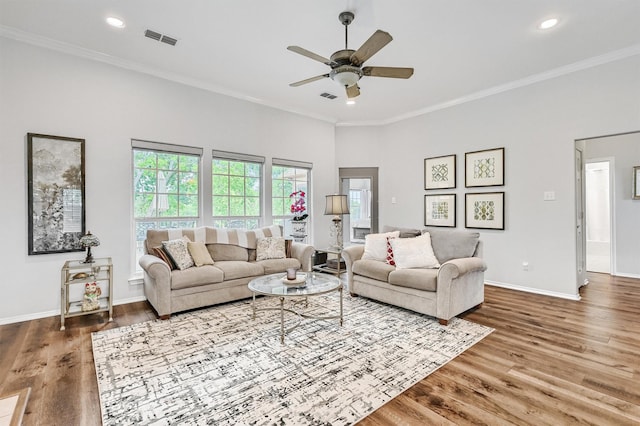 living room with baseboards, visible vents, wood finished floors, and a ceiling fan