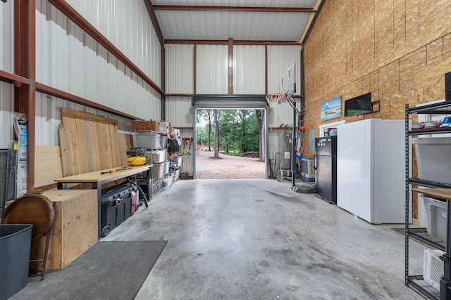 13533 Fm-1567 W, Brashear, TX 75433 - garage featuring freestanding refrigerator, metal wall, and a workshop area
